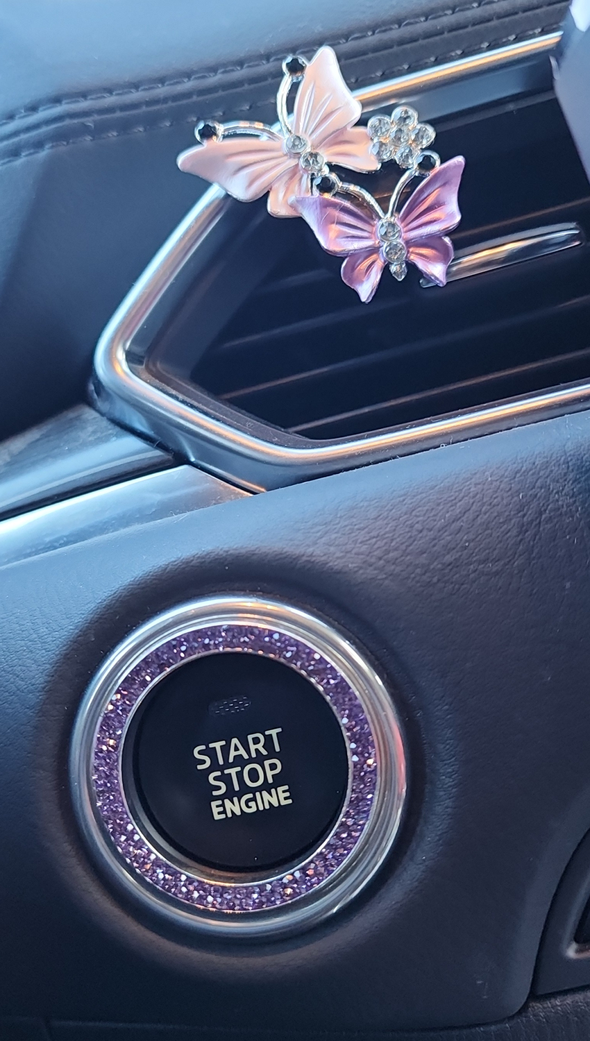 Sparkle bling on start engine button, and butterflies on vent in car.