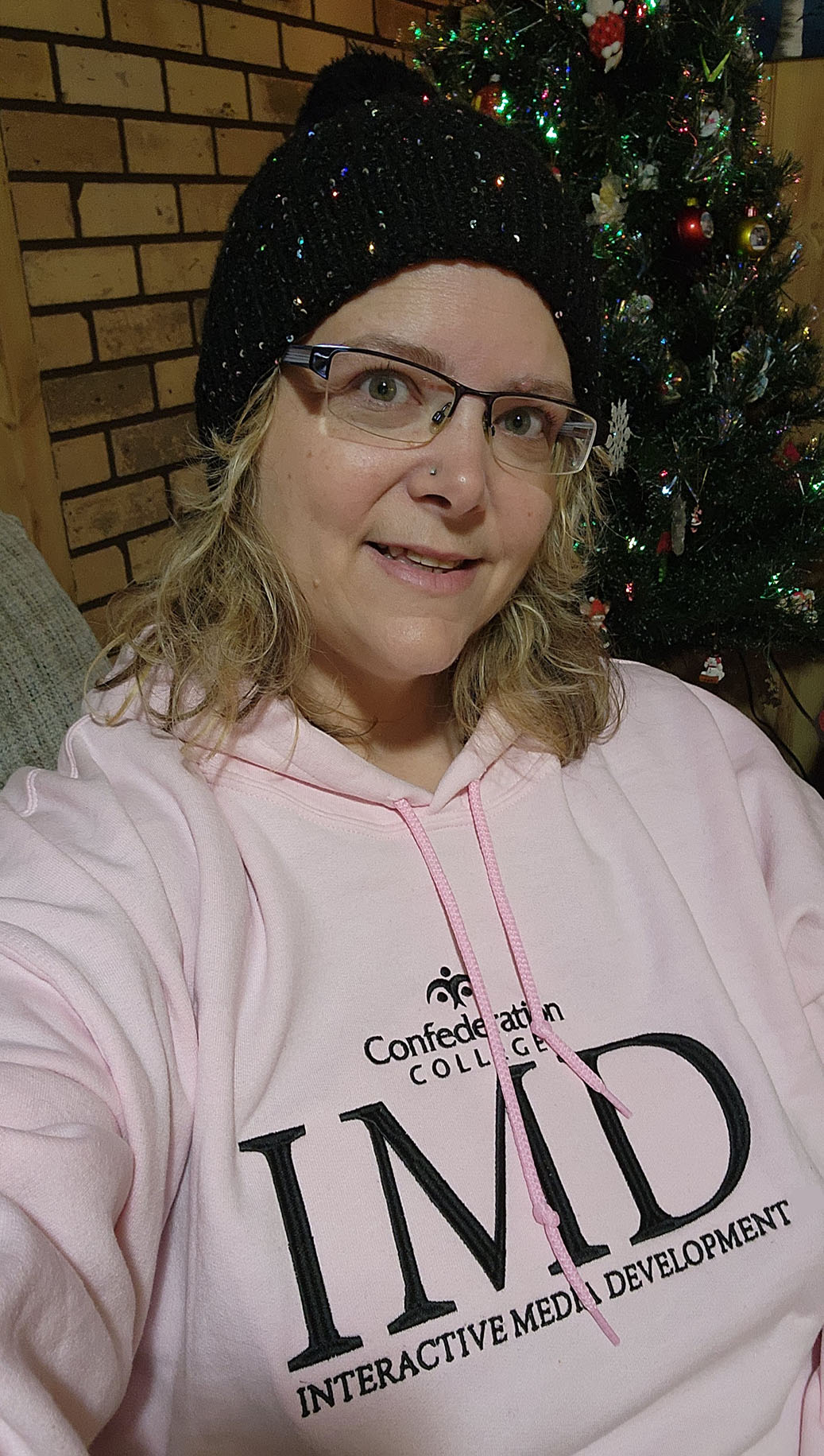 Michelle wearing a pink IMD hoodie and a sparkling hat.